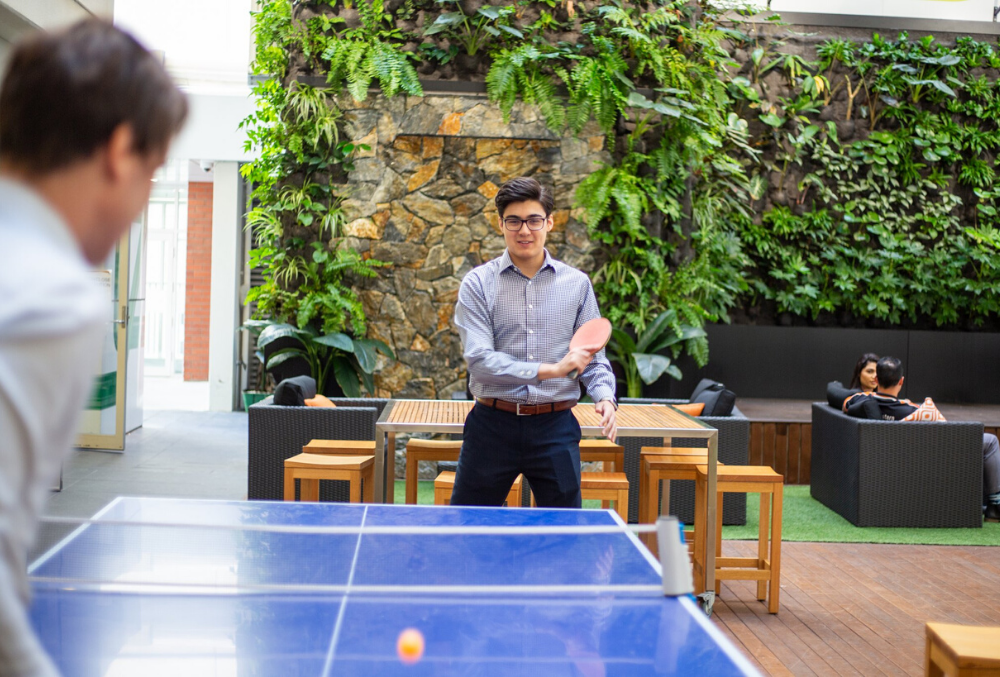 Matthew playing tennis with colleague