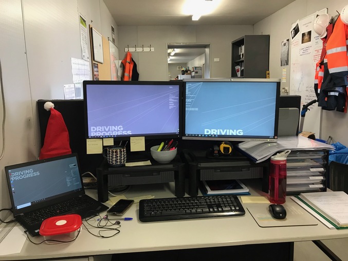 An office desk with a PC and a laptop