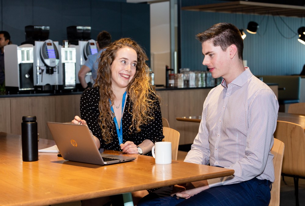 WSP Graduate- A young female professional conversing with a fellow grad.
