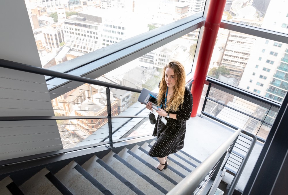 WSP Graduate- Young female professional walking upstairs to meet her client.