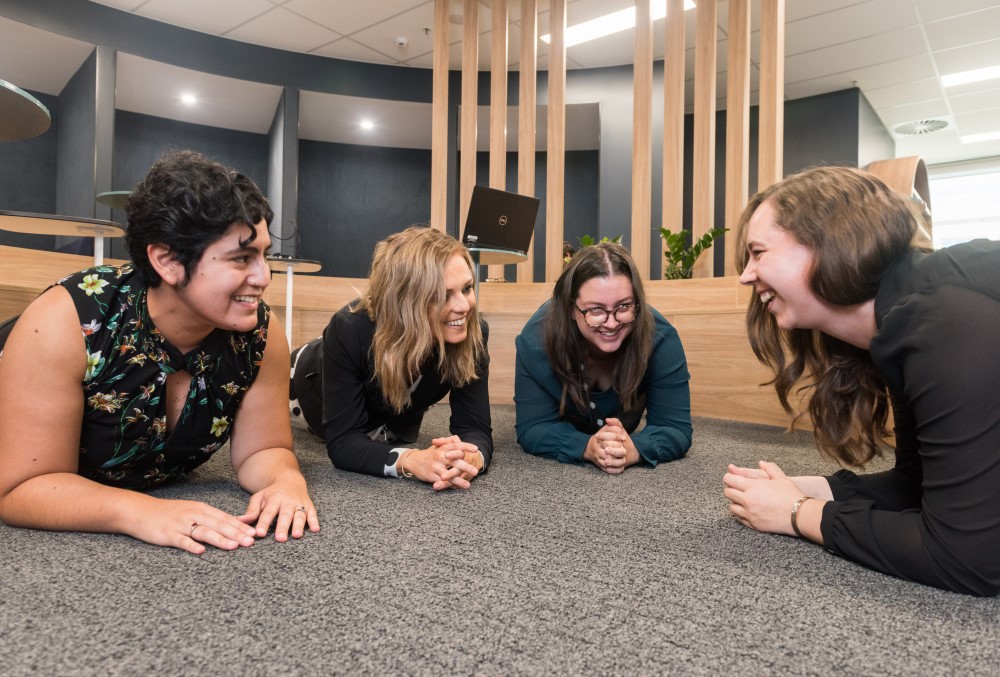 Australian National Audit Office (ANAO) Graduate - Young female professionals planking at work to energise and motivate themselves.