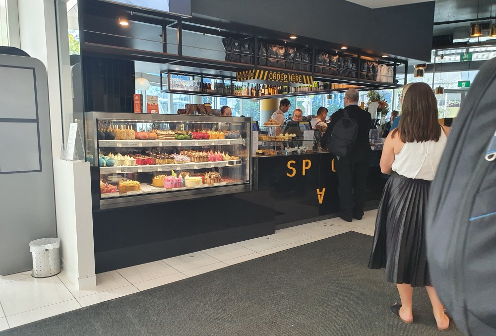 Capgemini Australia Graduate - Male professional queueing in a pastry shop.