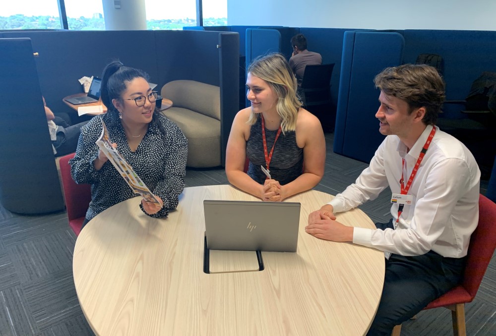 Coles Graduate - Young female professional on a meeting with her team.