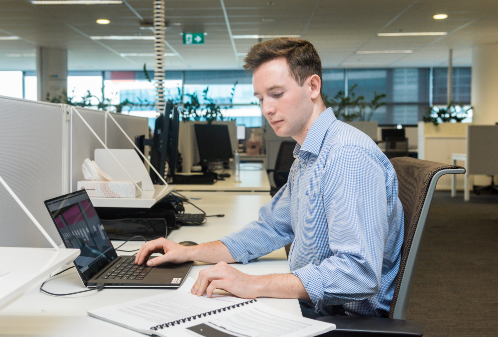 Downer Graduate- Young male professional checking on his laptop.