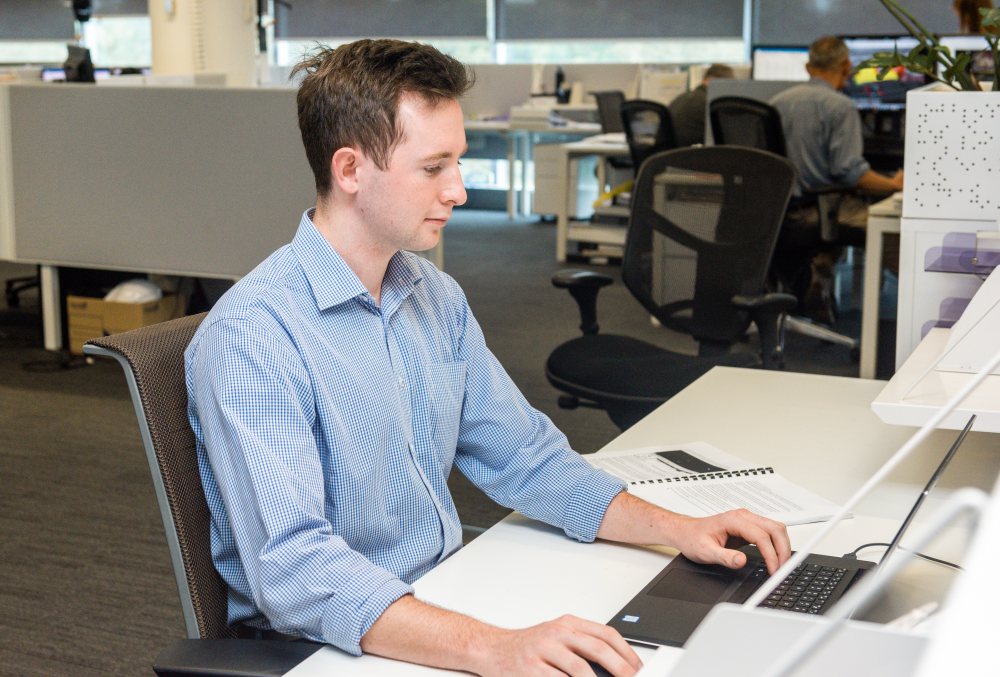 Downer Graduate- Young male professional working on his computer.