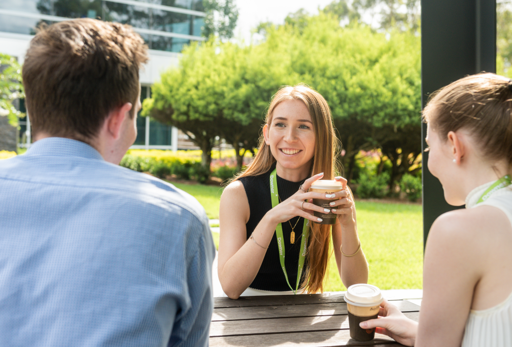 Downer Graduate- Young executives meeting over lunch with other grads.