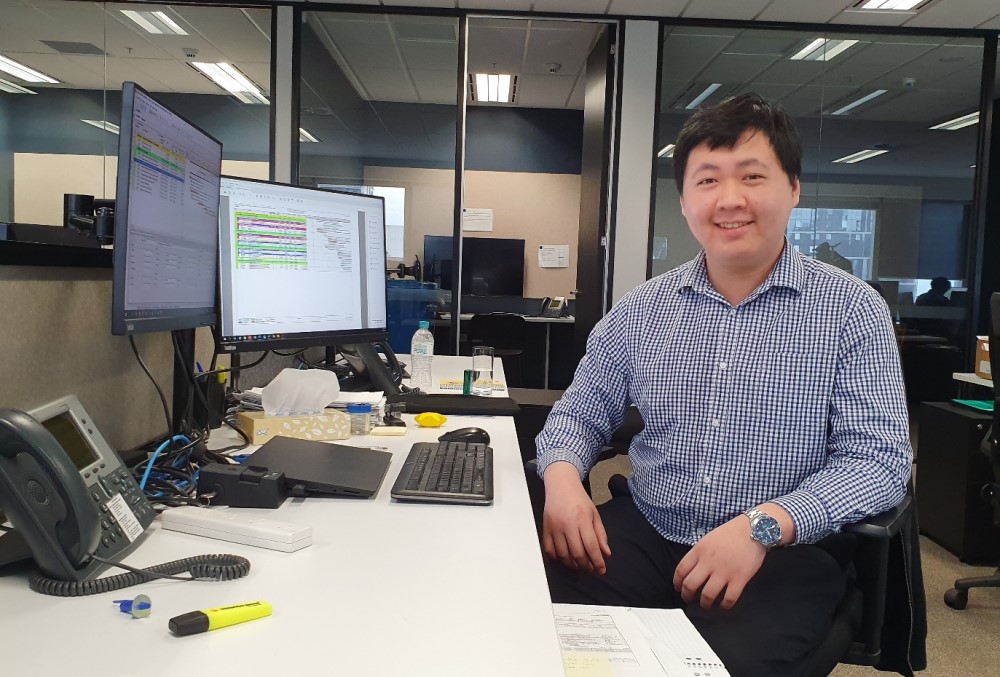 FTI Consulting Graduate- Male consultant sitting on his desk