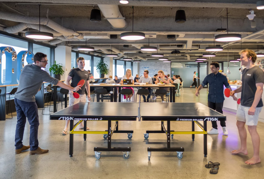 IMC Graduate- Male professional playing table tennis with friends after work.