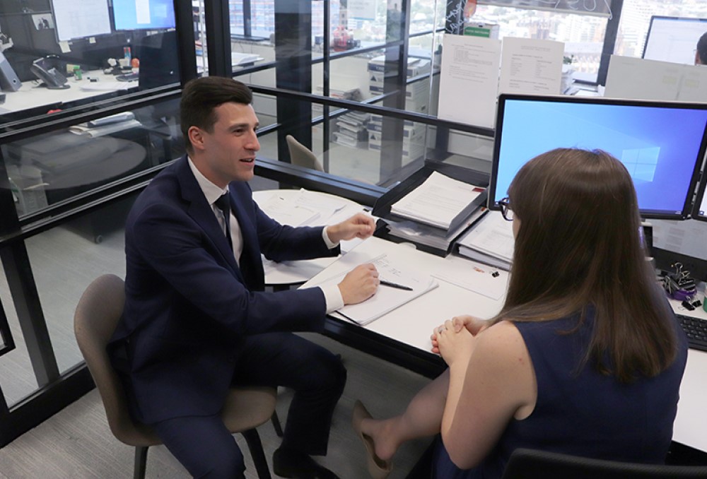 Sparke Helmore Lawyers Graduate - Young male lawyer conversing with his colleague.