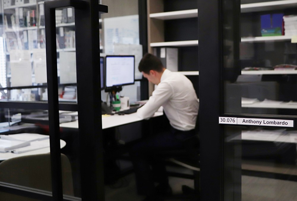 Sparke Helmore Lawyers Graduate - Young male lawyer sitting on his desk.