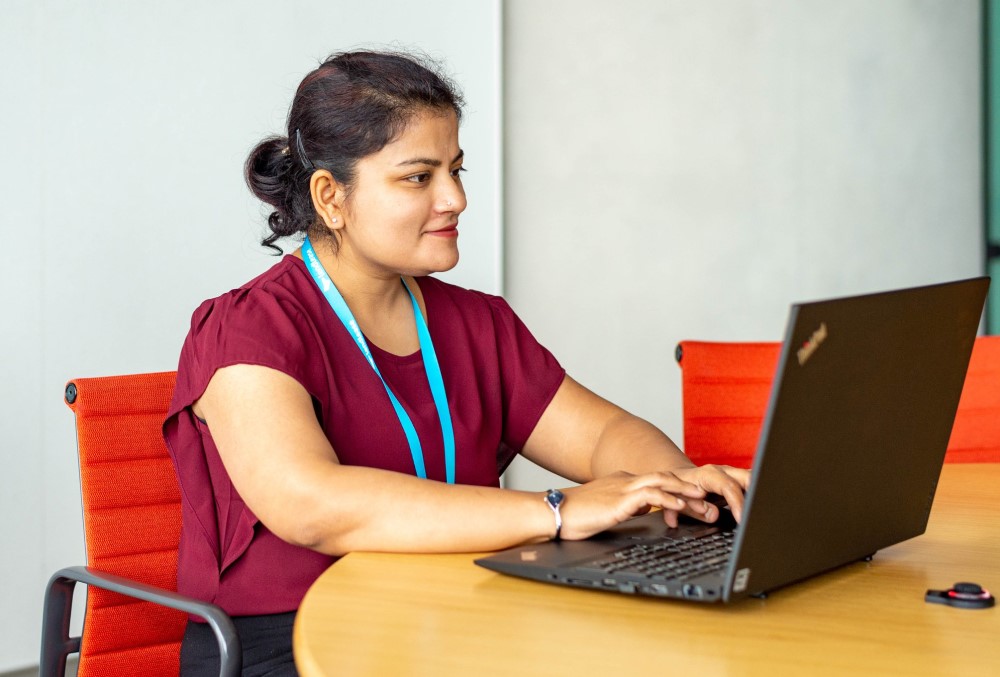 The Data School Graduate - Female professional working on her laptop.