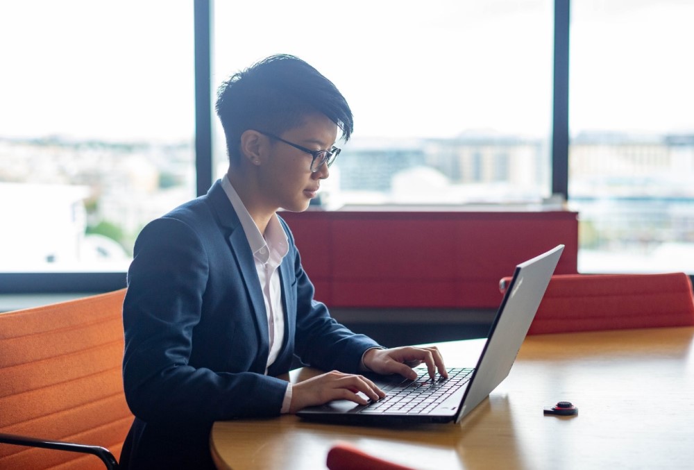 The Data School Graduate - Young female professional working on her laptop